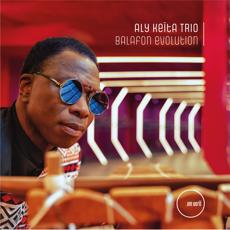 Aly Keïta - Balafon Evolution cover artwork. A color photo of Aly Keïta wearing sunglasses.