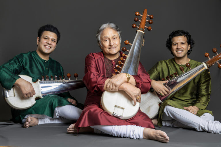 a photo of Amjad Ali Khan and his sons, Amaan Ali Bangash and Ayaan Ali Bangash, trhey are all holding sarods.