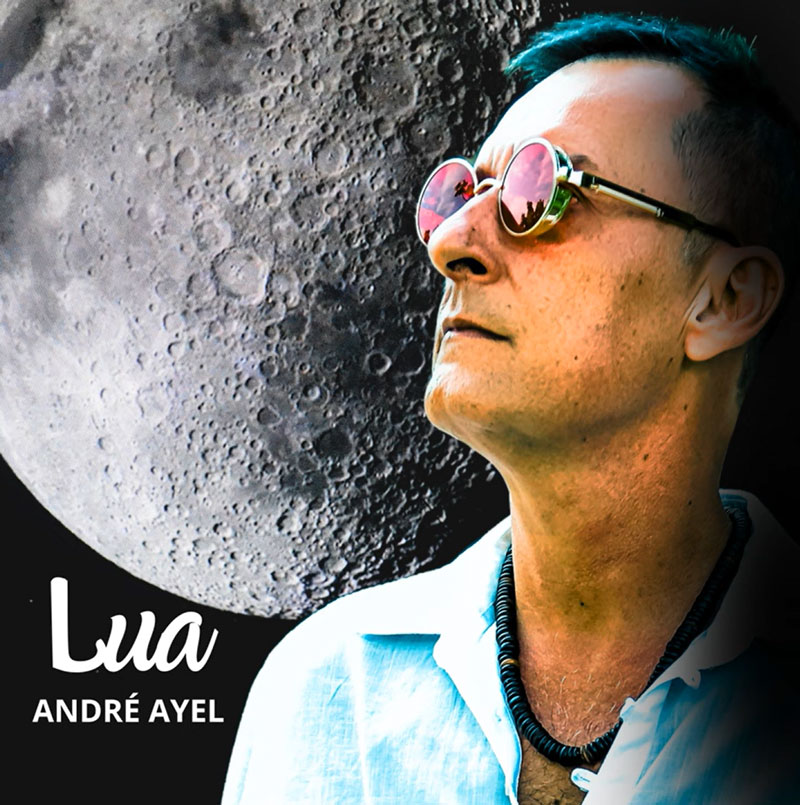 “Lua” by André Ayel single cover. The artist next to a large full moon.