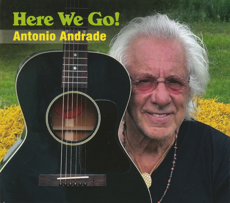 Antonio Andrade - Here We Go cover artwork. A photo of Antonio next to a black guitar.