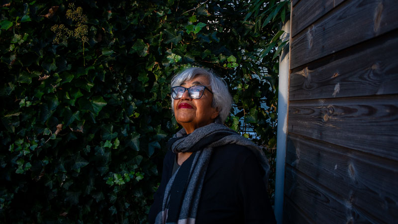 Atiya Khan standing outdoors with a greenery background.