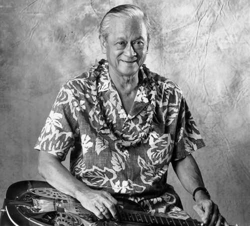 Black and white photo of Barney Isaacs holding a Hawaiian guitar.