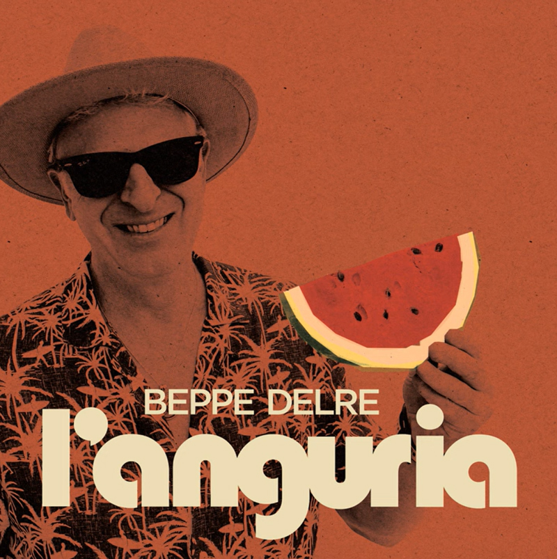 Beppe Delre L’anguria cover artwork. A photo of the artist wearing a tropical shirt and hat, holding a slice of watermelon.