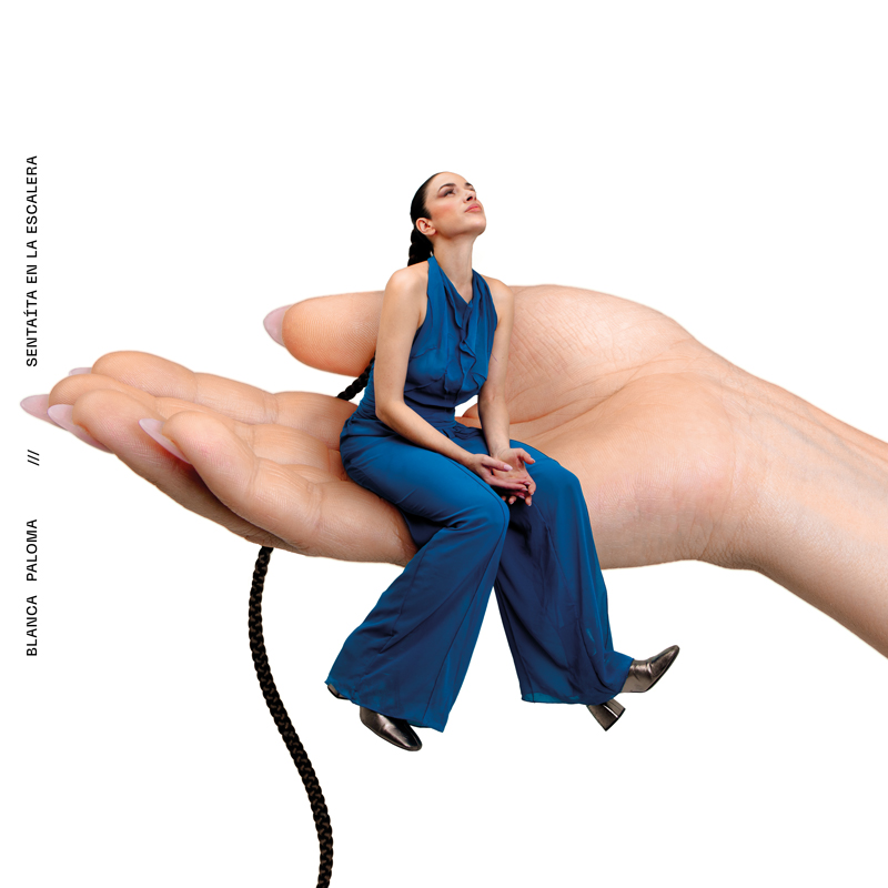 Blanca Paloma - Sentaita en la escalera (Portada) cover artwork. Blanca appears as a very small woman wearing a blue outfit sitting on a giant human hand.