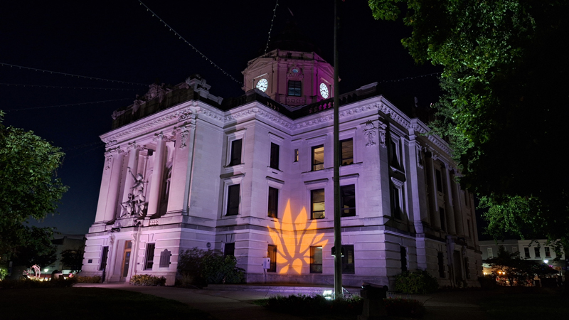 Bloomington during the lotus Festival 2025. a building with a Lotus Festival logo projection.