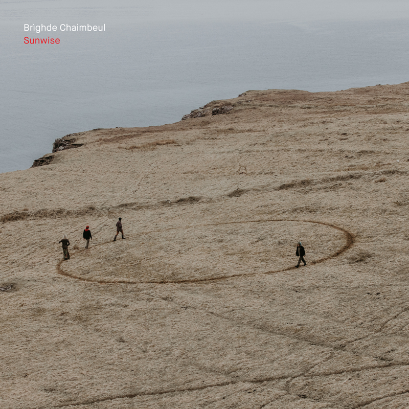 The album cover for Brìghde Chaimbeul – Sunwise features a windswept coastal landscape with four figures walking in a large, faintly traced circle on a barren, grassy plateau.
