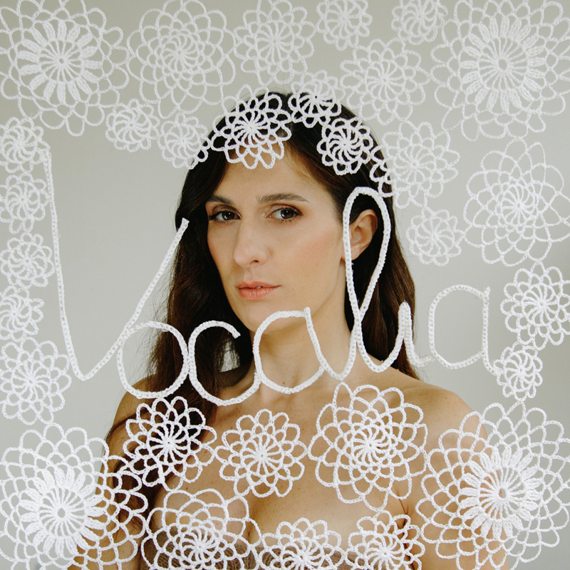 Vocàlia Carolina Bubbico, cover artwork. a photo of Carolina behind white cloth-like patterns.