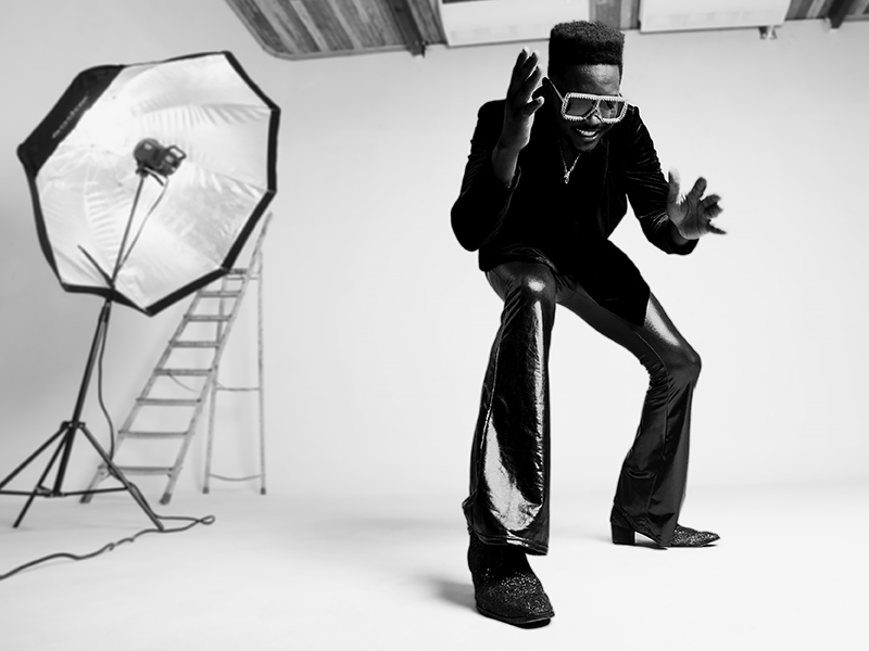 Cimafunk black and white photo. Leaning down, wearing large eyeglasses.