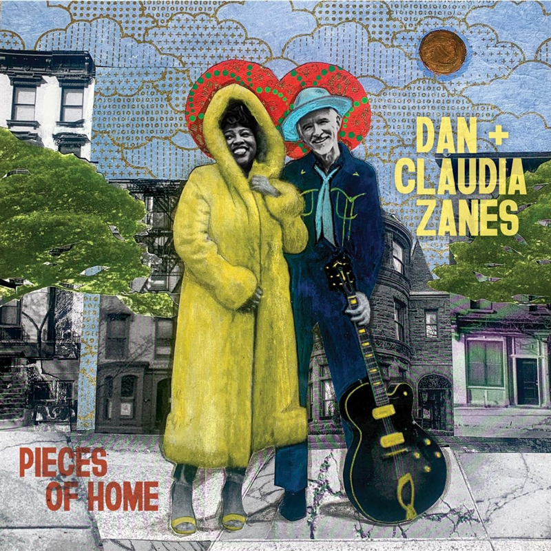 Dan + Claudia Zanes - Pieces of Home standing in the street in winter clothes. Dan is holding an electric guitar.