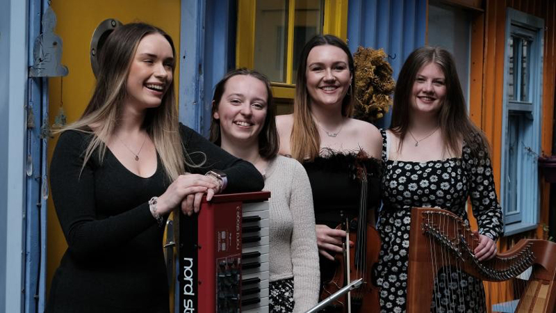 Dàna band photo. Four young women musicians.