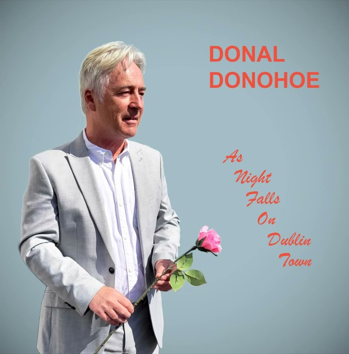 Donal Donohoe - As Night Falls on Dublin Town cover artwork. A photyo of the artist holding a rose.