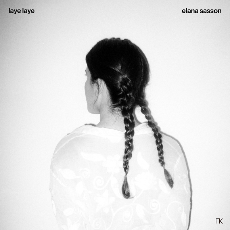 The album cover for Laye Laye by Elana Sasson features a black-and-white photograph of a woman seen from behind. Her dark hair is braided into two plaits, and she wears a sheer, floral-patterned garment draped over her shoulders.