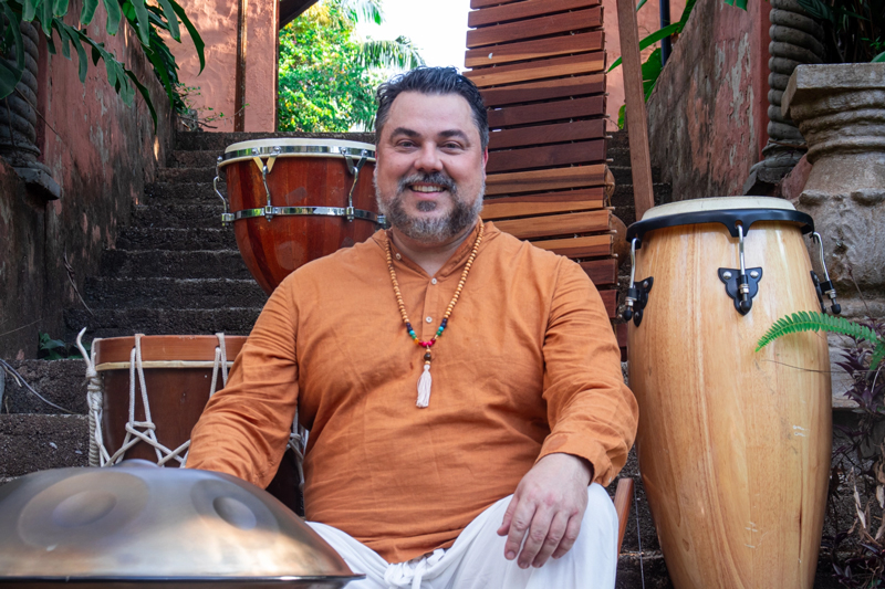 Fabio Bergamini sitting outdoors next to some of his musical instruments.