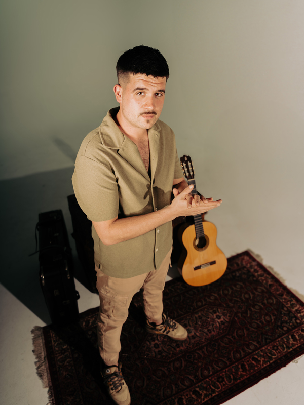 Fraderita standing next to a flamenco guitar