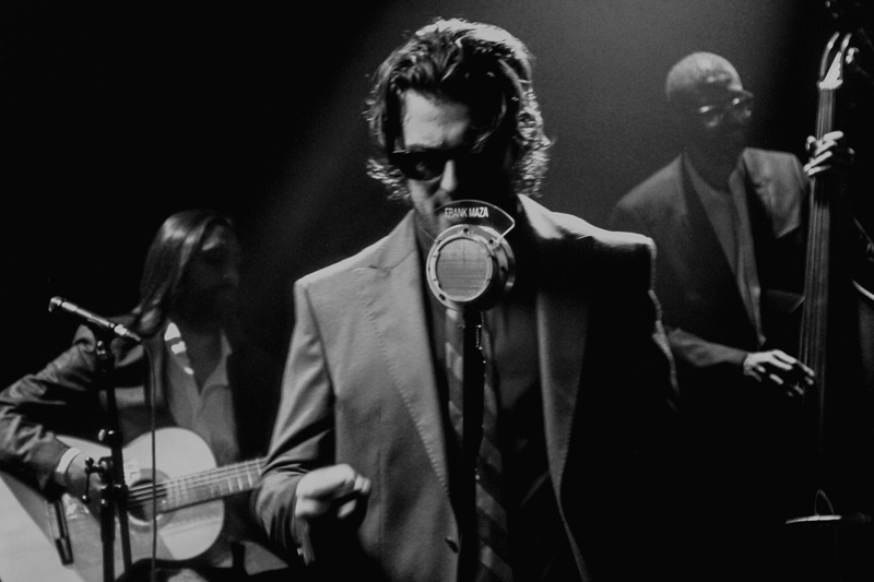Frank Maza black and white photo. Frank in front of microphone.