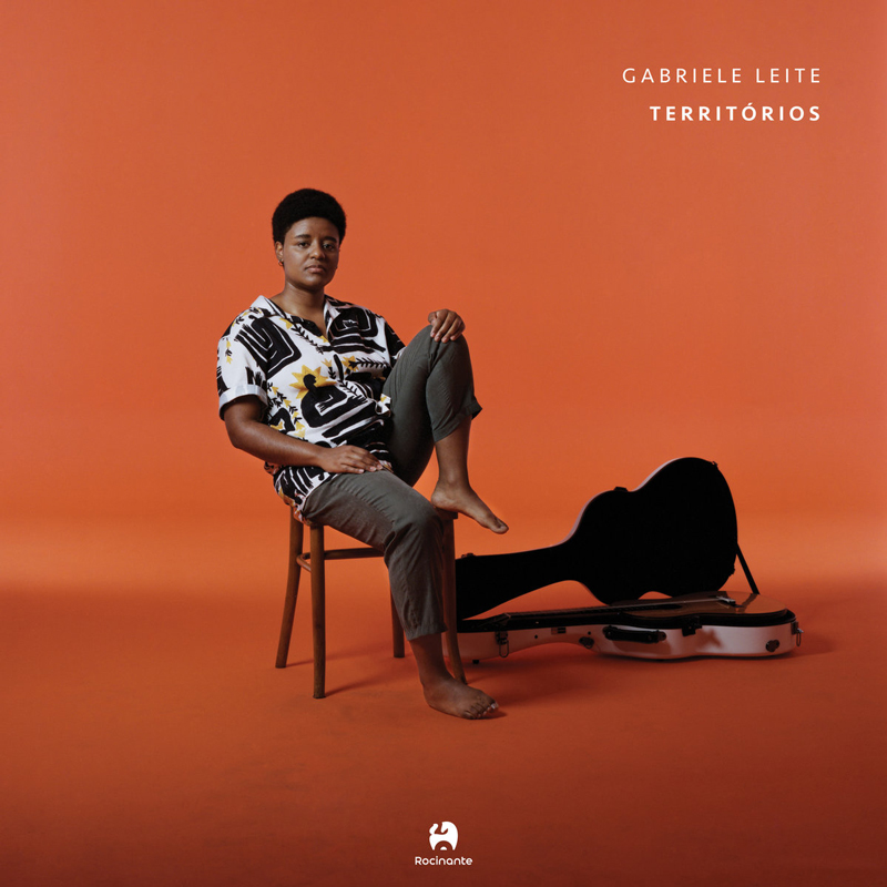 Gabriele Leite - Territórios cover artwork. The artist sitting on a chair next to her guitar case.