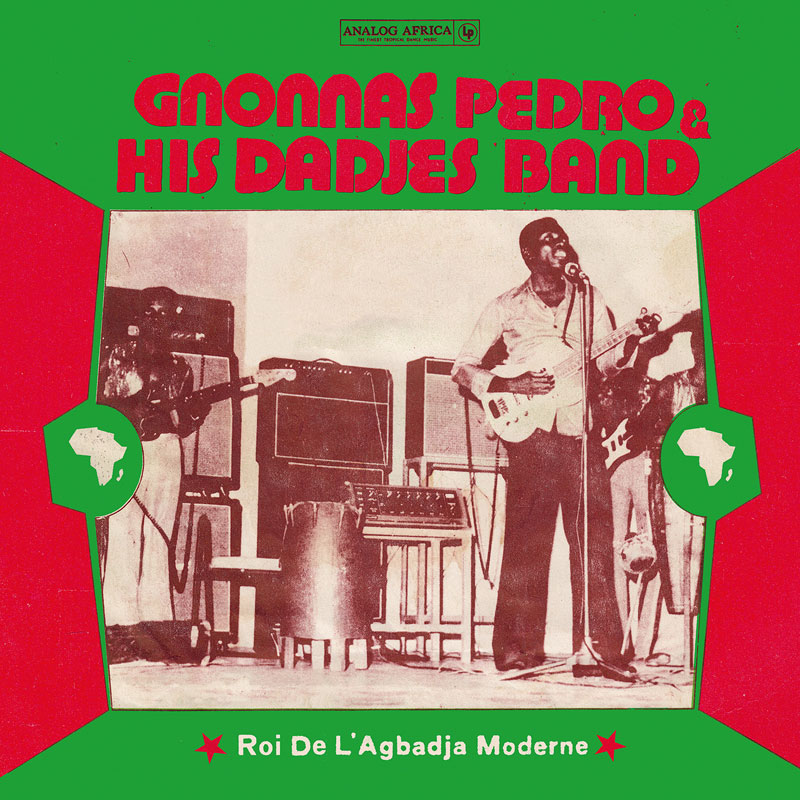 The album cover for Roi De L’Agbadja Moderne by Gnonnas Pedro & His Dadjes’ Band has a vintage, retro aesthetic, dominated by red and green colors. The central element is a sepia-toned photograph of the band performing live, with Gnonnas Pedro at the microphone, playing a guitar. Surrounding the image are geometric red and green shapes, with small white African continent icons on each side.