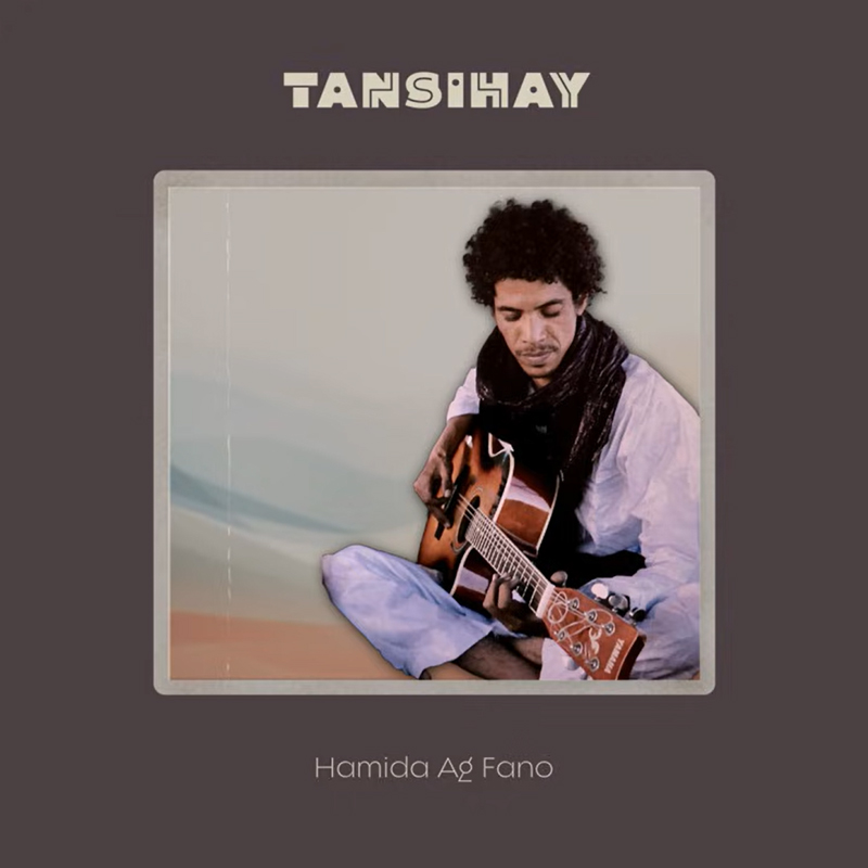 Hamida Ag Fano Tansihay cover artwork. A photo of Hamida playing guitar, sitting on the ground with a desert landscape behind.