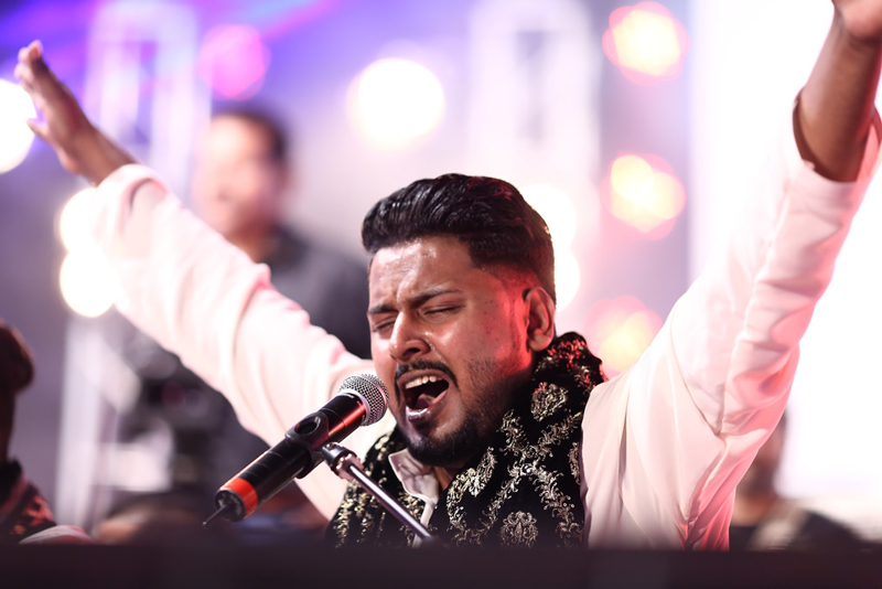 Hamza Akram Qawwal Ens by Arts Council of Pakistan Karachi_. Hamza singing with arms in the air.