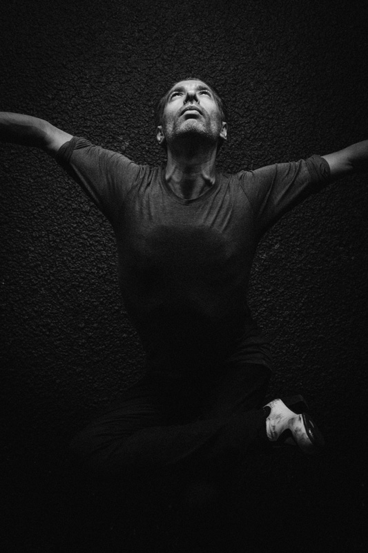 Israel Galván - Photo by Nicolas Serve. Black and white photo of Israel wit his arms streched out.
