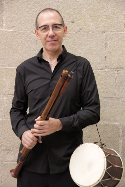 Jaime Muñoz holding flures and a small drum held by his left arm