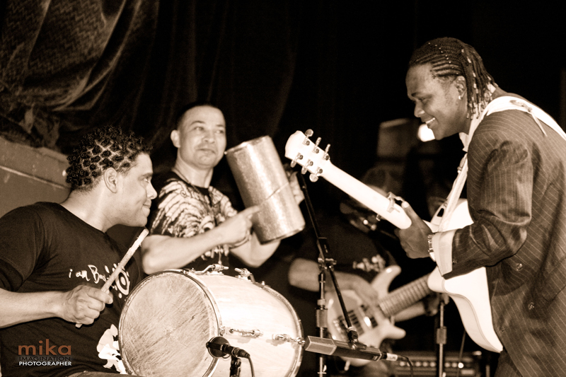Joan Soriano, roots bachatero - Photograph: Mika Mika © iASO Records, 2011. Black and white photo of Joan and two other musicians.