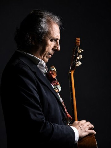 Juan Carlos Romero profile photo, holding a guitar.