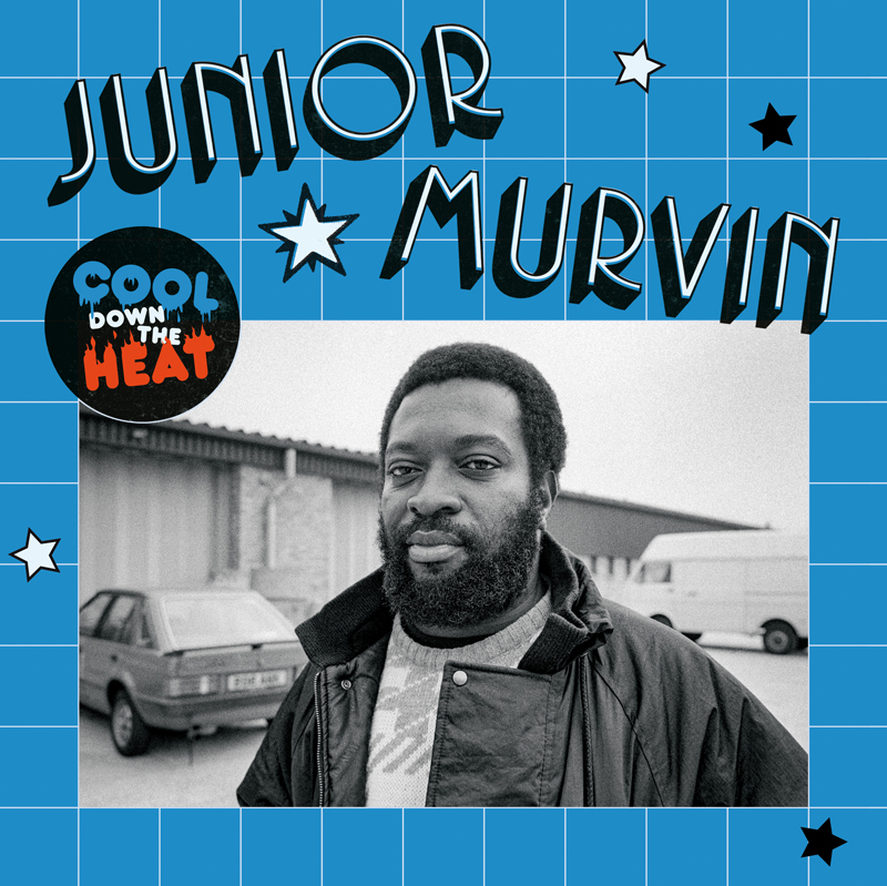 The album cover features a black-and-white photo of Junior Murvin standing outdoors near cars and a warehouse, framed by a blue grid background decorated with stars. His name, “Junior Murvin,” appears in large black-and-white letters at the top. On the left, a circular badge reads “Cool Down the Heat” in blue, red, and black text.