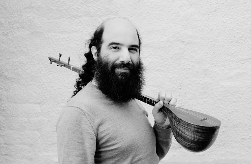 Kiya Tabassian carrying a setar over his shoulder.