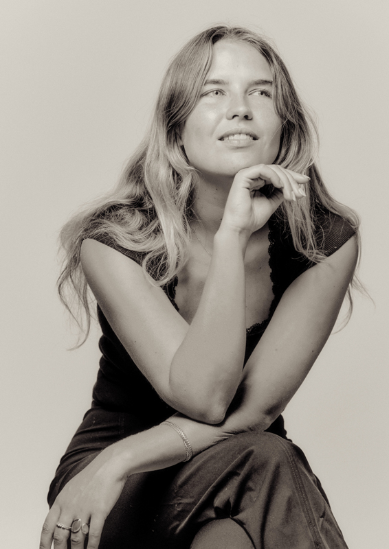 Liza Lo by Kayla Raquel. Black and white photo of Liza sitting.