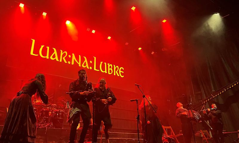 Live photo of Luar Na Lubre on stage with red lighting.