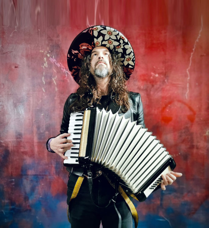 Luca Bassanese wearing a hat playing accordion