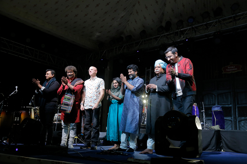 Rhythms of India musicians on stage receiving an ovation.