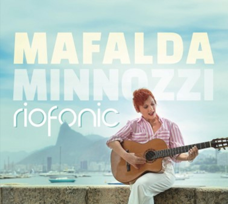 Mafalda Minnozzi - Riofonic cover artwork. Mafalda playing a guitar, sitting with a Rio landscape behind her.