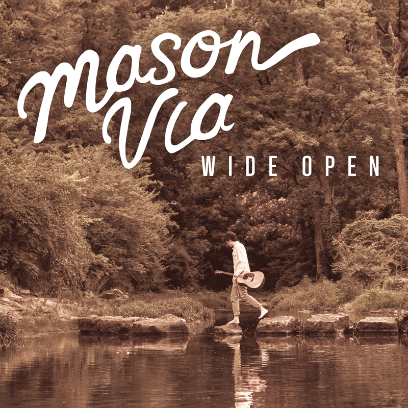 Mason Via - Wide Open cover artwork. a light brown photo of Mason Via walking by the side of a lake or river, holding his guitar, in front of woods.