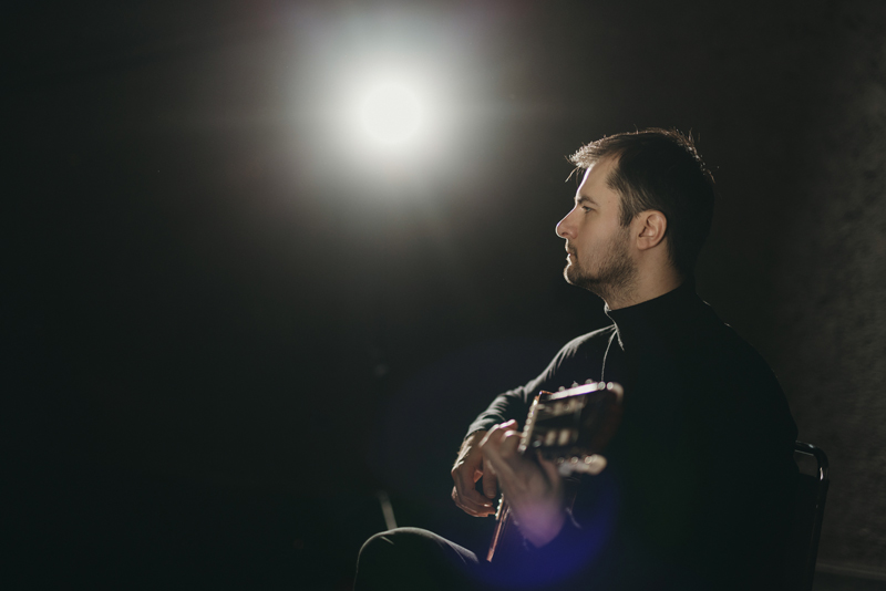 Mirza Redžepagić in sitting position, playing guitar.