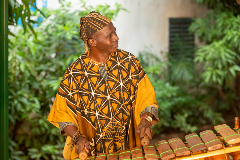 Neba Solo - Photo by Aboubacar Traoré. Neba playing balafon outdoors.