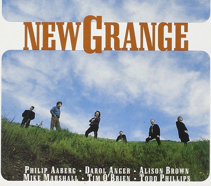 New Grange cover artwork. A photo of the artists scattered on top of a green hill.