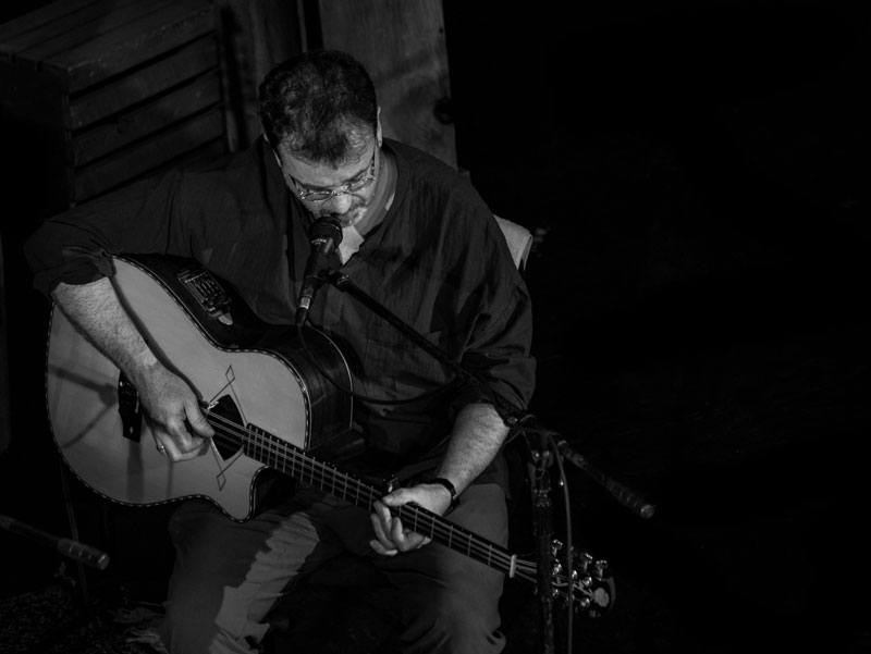 Pat Broaders playing guitar. Black and white photo.