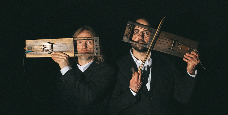 Puuluup - Photo by Taavi Arus. The musicians holding their musical instruments over their faces.