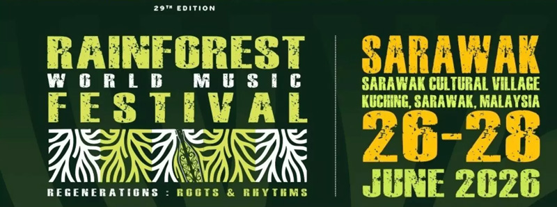 Rainforest World Music Festival 2026 banner. Yellow and orange letters over a dark green background. A stripe of roots appears under Festival.