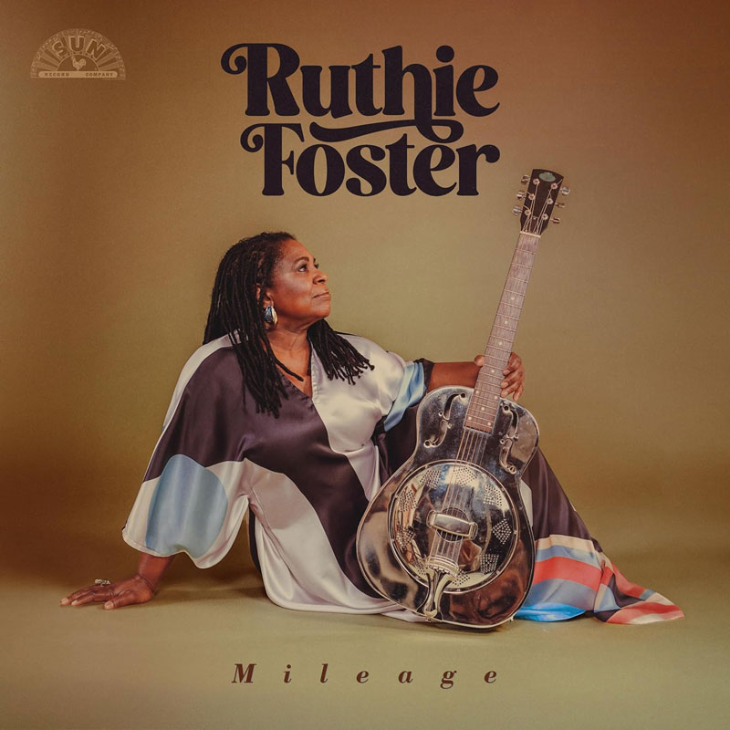 Mileage by Ruthie Foster cover artwork. Ruthie Foster sitting on the floor holding a steel guitar.