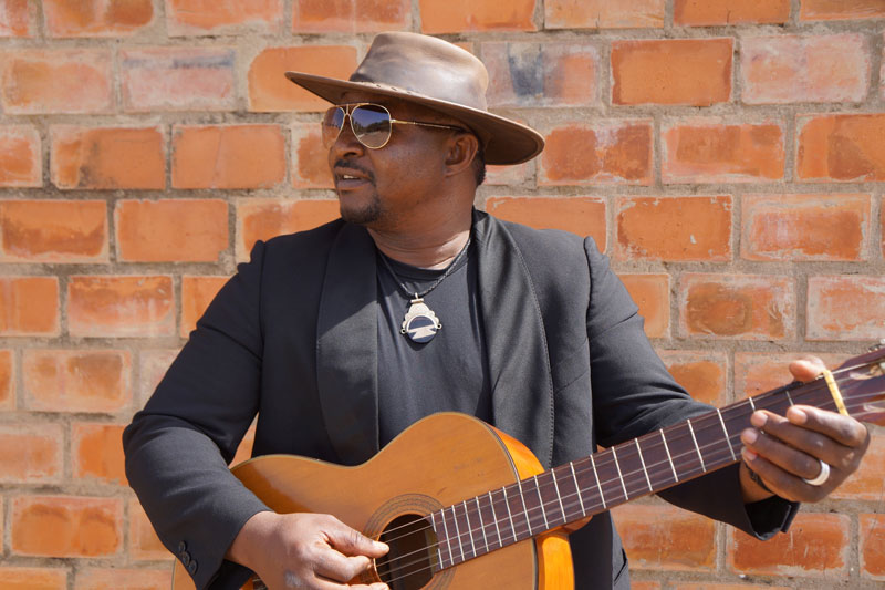 Samba Toure playing guitar, wearing a hat and sunglasses - Photo by Karim Diarra 0001