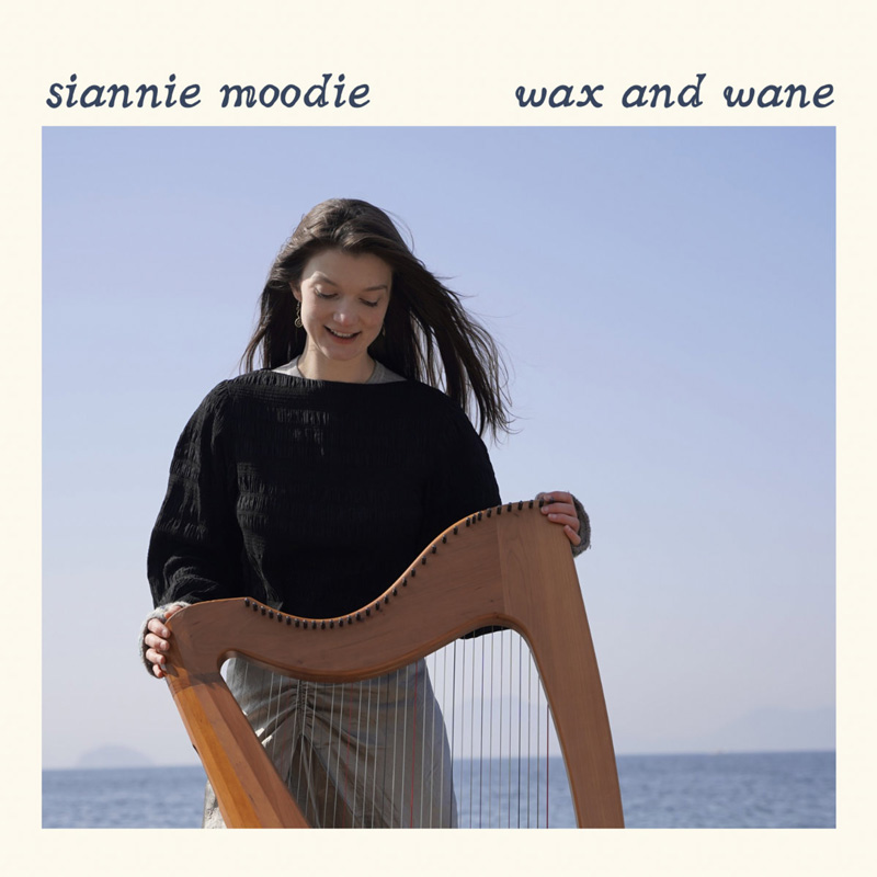 Siannie Moodie Wax and Wane cover artwork. A photo of Siannie holding a harp outdoors, by the sea.