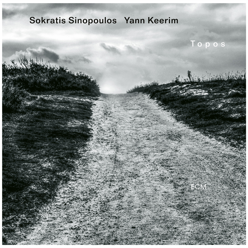 The album cover shows a black-and-white photograph of a dirt path rising toward a bright, clouded horizon, flanked by dark grass.