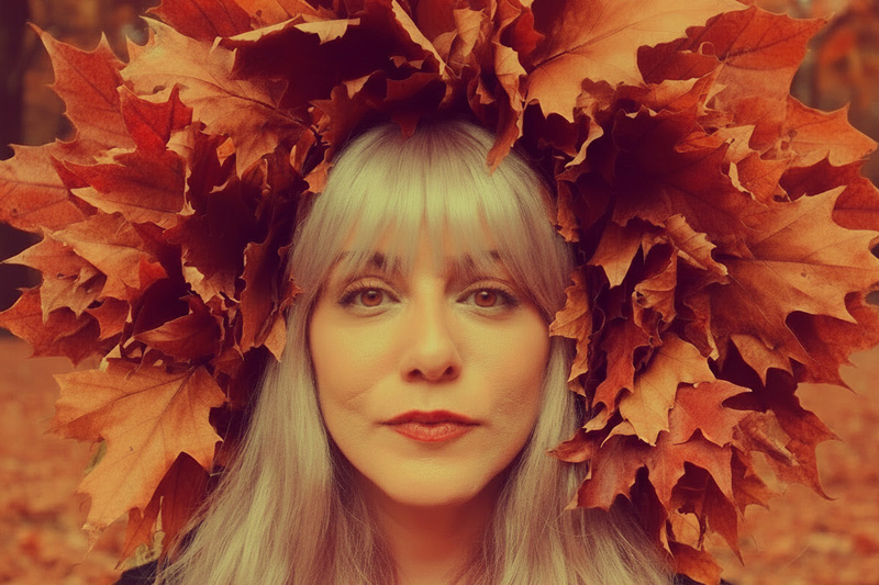 Stella Papalamprou headshot. Blond woman with leaves around her head.