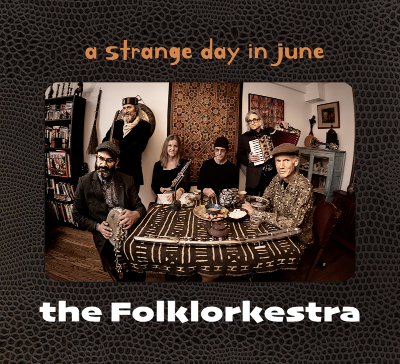 The Folklorkestra - A Strange Day in June cover artwork. a photo of the band around a table.