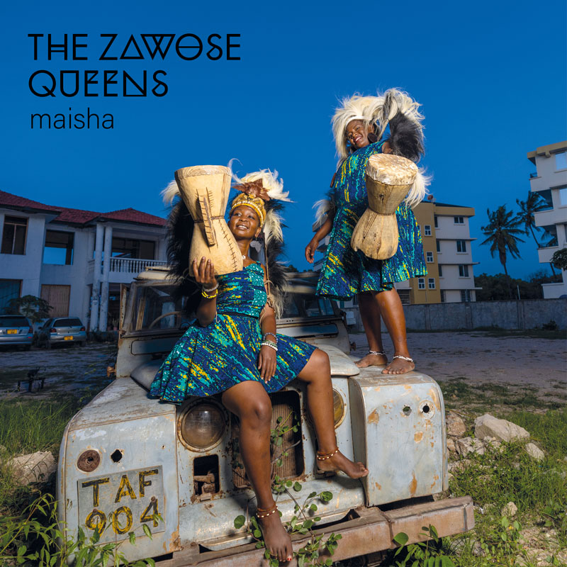 The Zawose Queens - Maisha cover artwork. a photo of the two women sitting and standing over a Land Rover holding drums.