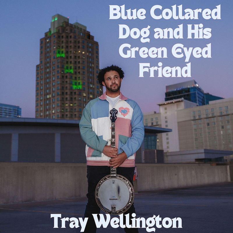 Tray Wellington - Blue Collared Dog and His Green Eyed Friend cover artwork. The artist standing on a rooftop in a city holding a banjo.