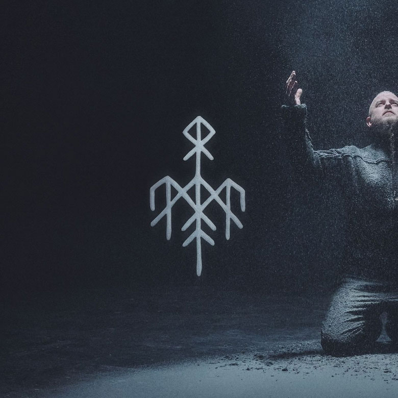 Wardruna - Hertan cover artwork. It shows a rune in the middle and Eivar on the right kneeling down.
